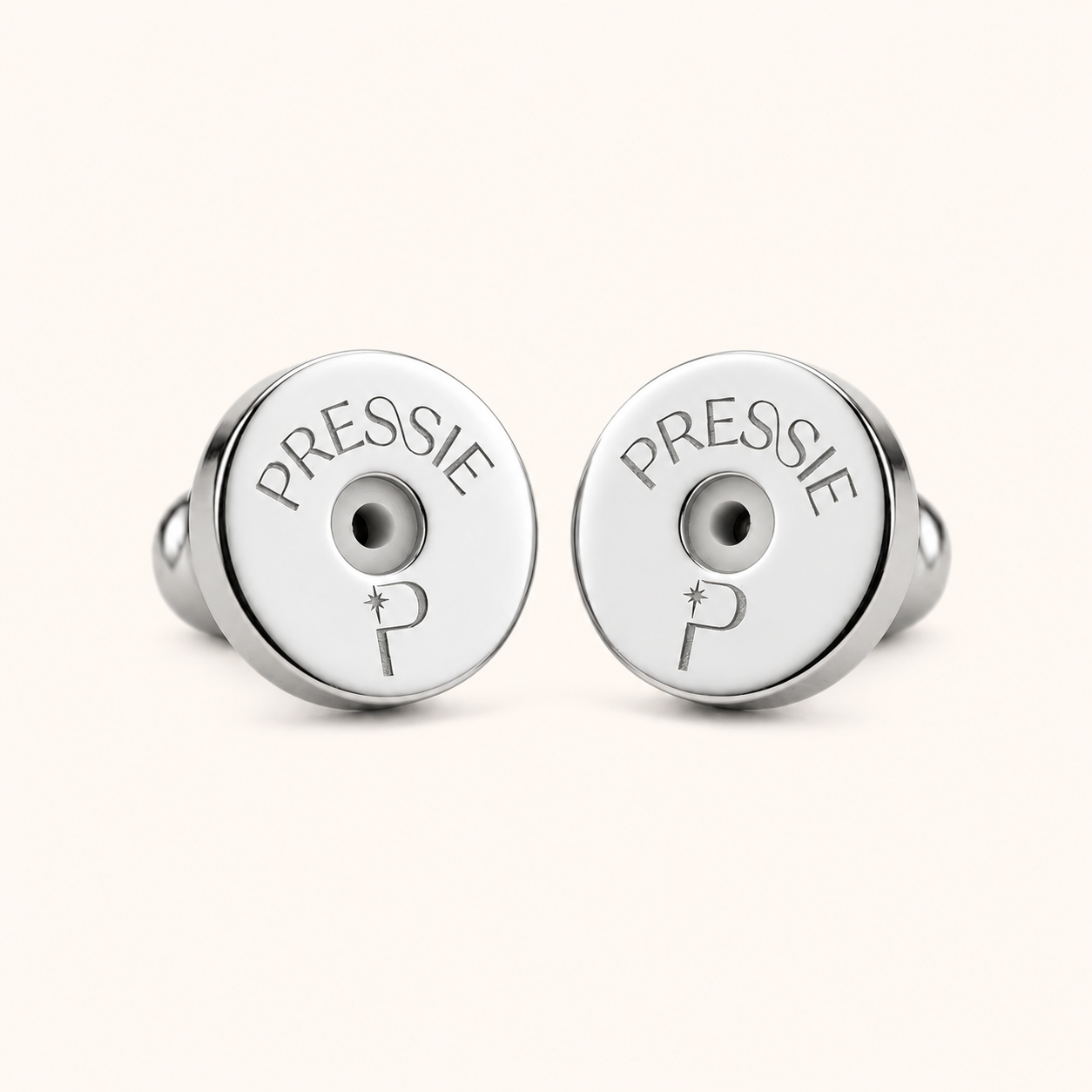 Two silver pressie charms with engraved text on a white background